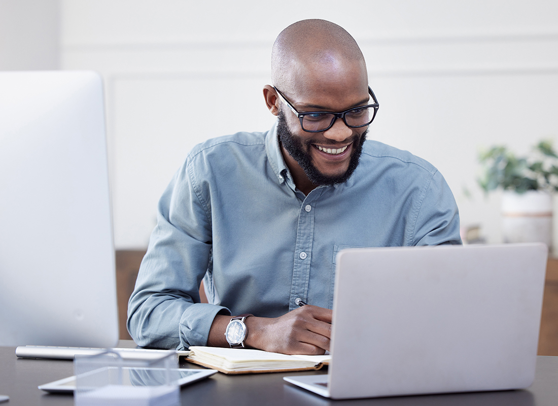 Read Our Reviews - Cheerful Man Looking at His Laptop in an Office