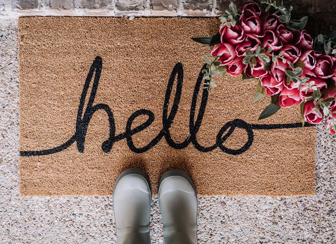 About Our Agency - Close-up of a Person's Boots on a Hello Mat