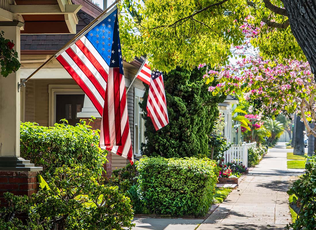 Contact - Row of Homes With Flags on a Spring Day